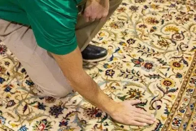 Technician inspecting carpet fibres during professional rug cleaning service in Calgary to ensure deep and effective cleaning