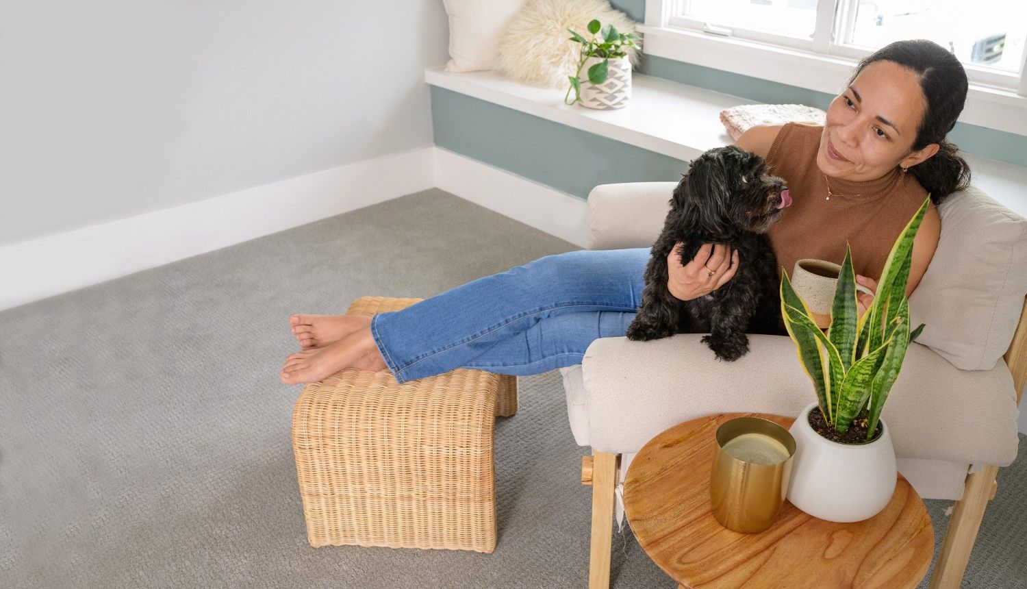 Woman relaxing with her dog in a fresh, odour-free living room after professional pet urine odour and stain removal by Eco Valley Chem-Dry in Calgary.