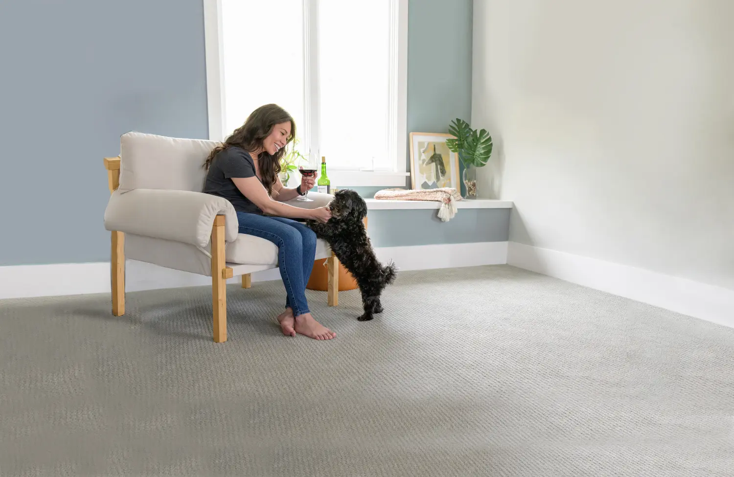 Woman relaxing on freshly cleaned carpet with dog after professional carpet cleaning service