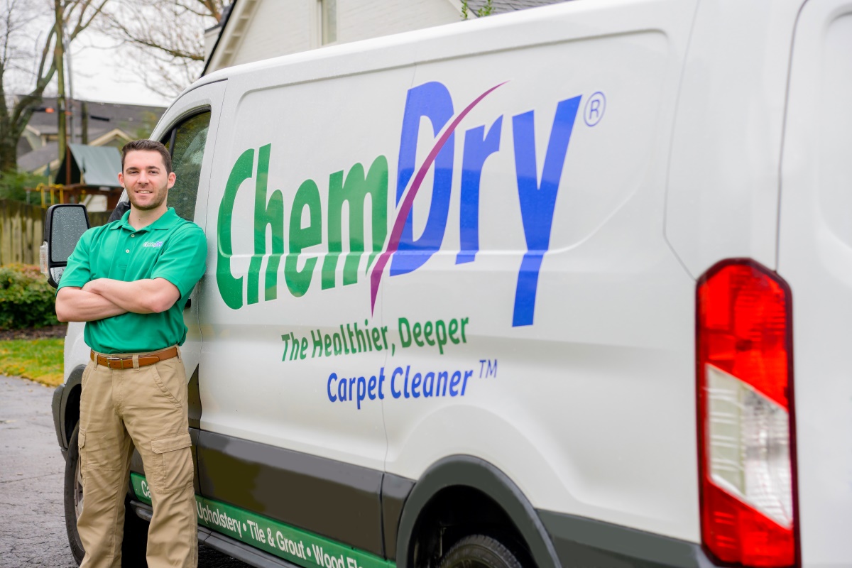 Eco Valley Chem Dry technician standing beside a Chem Dry service van in a Calgary neighborhood before a carpet cleaning appointment.