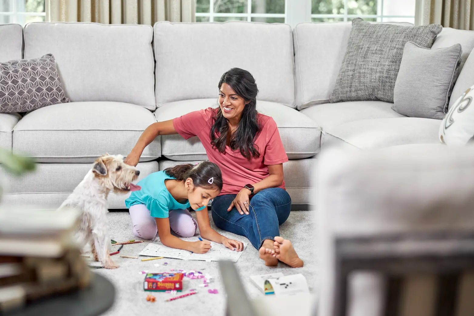 Mother and child enjoying a clean living room with their dog after professional Pet Odor Cleaning Services, creating a fresh and family-safe home