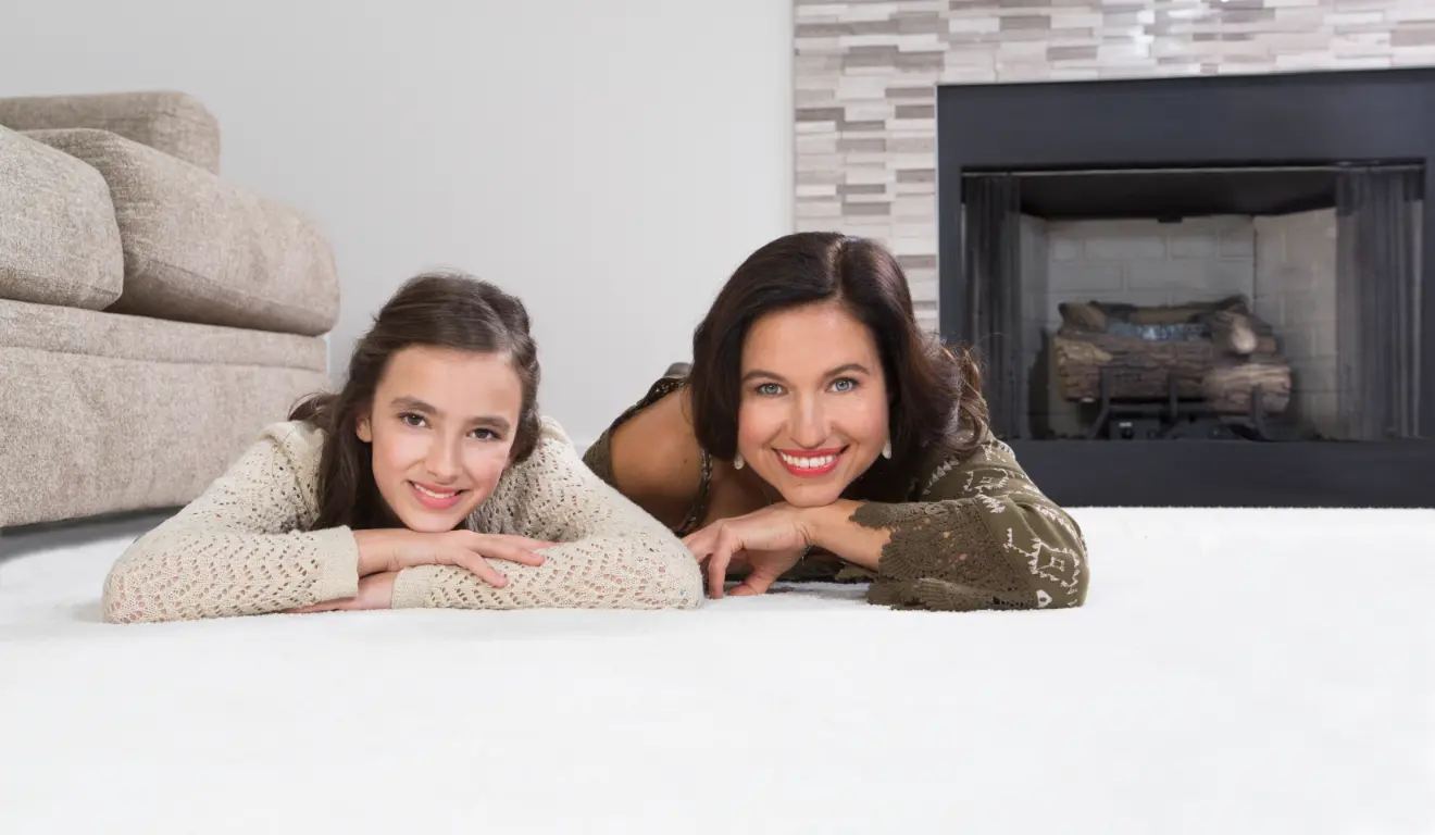 Family relaxing on freshly cleaned carpet at home, highlighting a healthier indoor environment after professional carpet cleaning