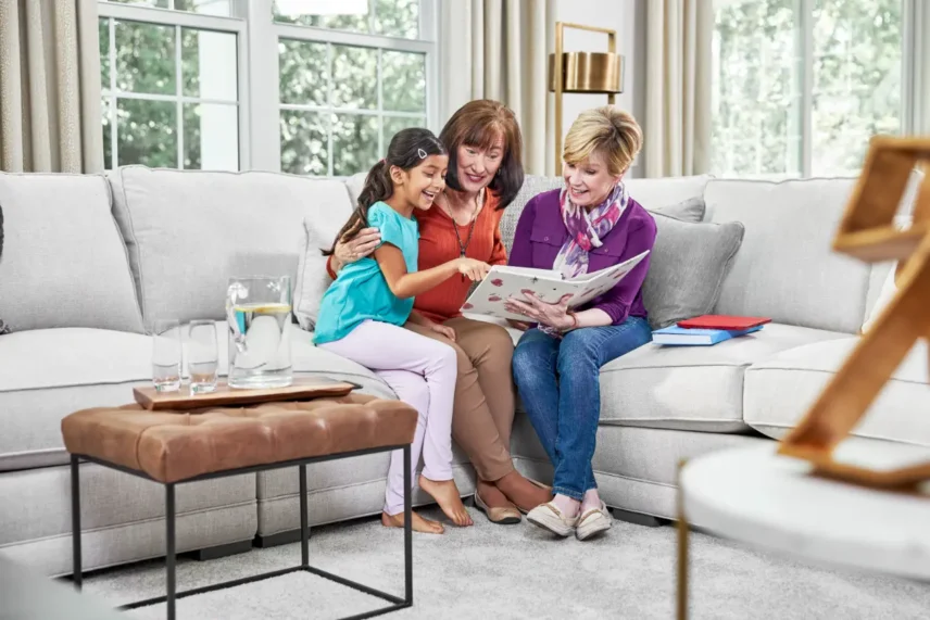Family relaxing on freshly cleaned carpet after safe professional carpet cleaning with non-harsh cleaning solutions