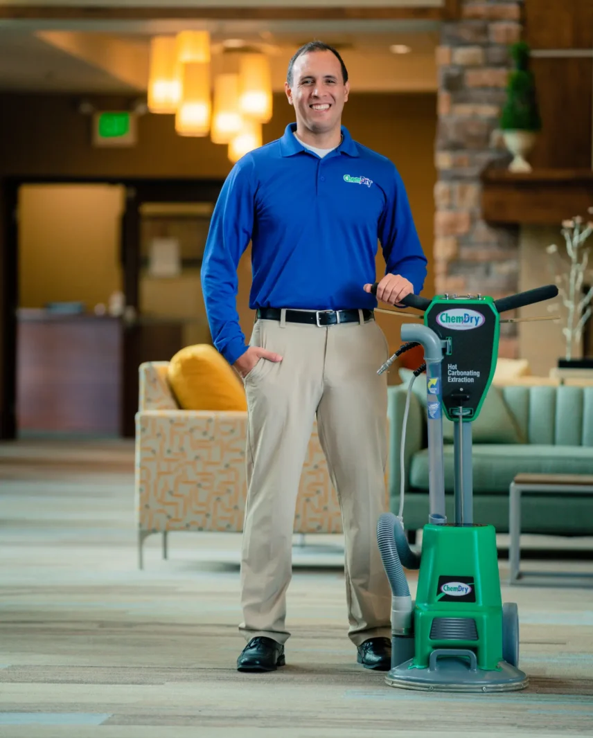 Professional carpet cleaning technician with stain removal machine ready for pet urine and deep carpet cleaning service