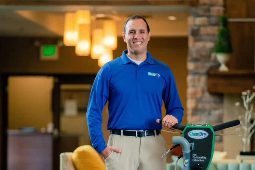 Okotoks carpet cleaning professional standing with carpet cleaning equipment during a residential carpet cleaning service