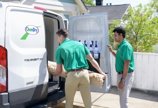 Technicians loading a rug into Eco Valley Chem-Dry van for professional rug cleaning service in Calgary