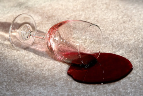 Red wine spill on carpet requiring professional stain removal