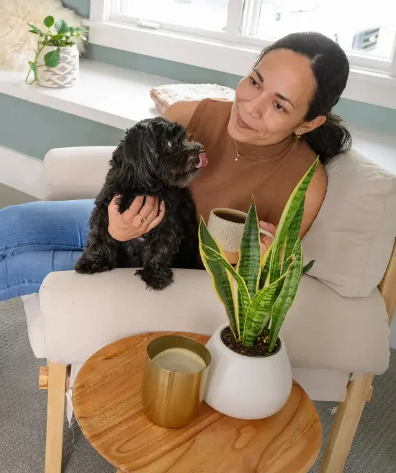Woman relaxing with her dog in a fresh home after carpet cleaning helped get rid of dog urine.