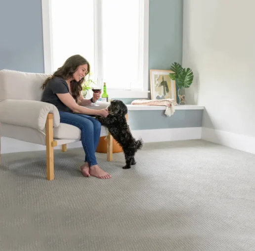 Woman with her dog on a clean carpet showing how carpet cleaning can remove urine smell.