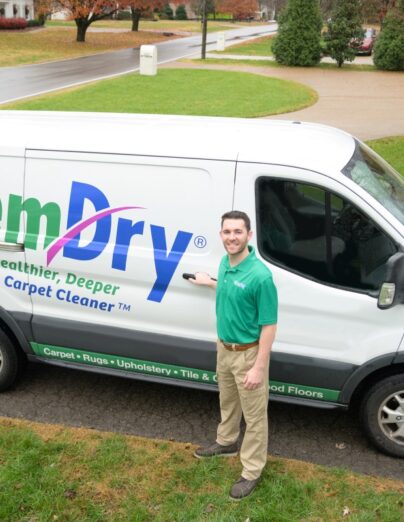 Cleaning services Cochrane technician arriving at a residential home with a service van, providing professional carpet and upholstery cleaning