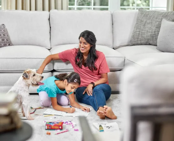 Family with a child and pet enjoying a clean living room after professional cleaning services Cochrane for carpets and sofas