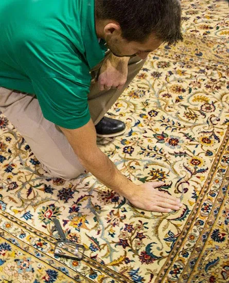 Eco Valley Chem-Dry technician inspecting an area rug before professional cleaning