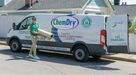on the spot carpet cleaning specialists 3 Eco Valley Chem-Dry technician carrying carpet cleaning equipment beside a professional service van.
