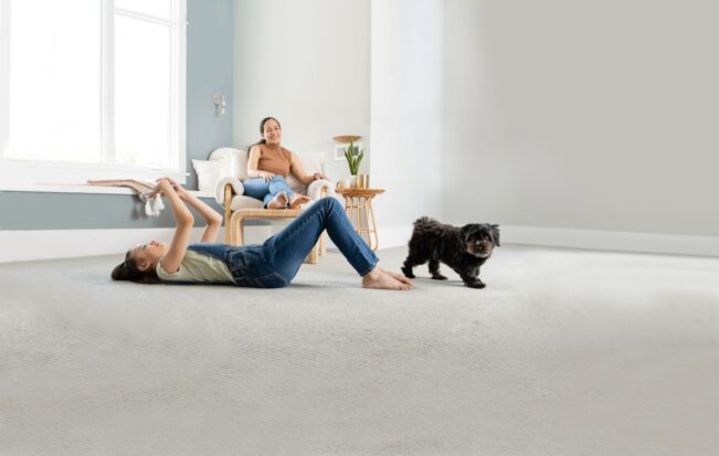 Family relaxing with their dog on a fresh carpet after carpet cleaning removed urine smell.